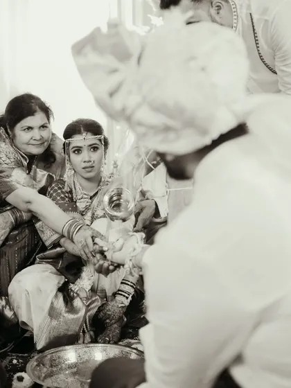 A black and white shot capturing a traditional moment during the wedding rituals.