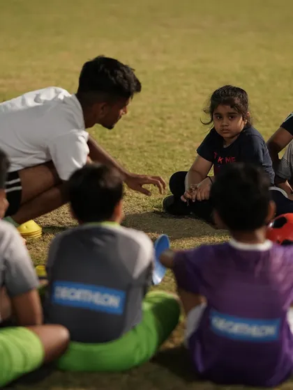 Coaching here is about more than just drills. A coach kneels down to connect with our youngest players, including a future Shewolf, explaining the importance of teamwork and strategy. We build players who are not just skilled, but also smart.