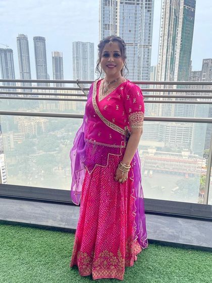 Our client looks beautiful against the city skyline in a custom pink and purple bandhani-style lehenga. This traditional design is perfect for festive occasions and family gatherings.