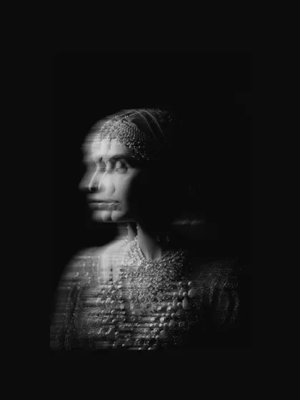 A striking and artistic black and white bridal portrait using a slow shutter speed to create a ghostly, multi-exposure effect.