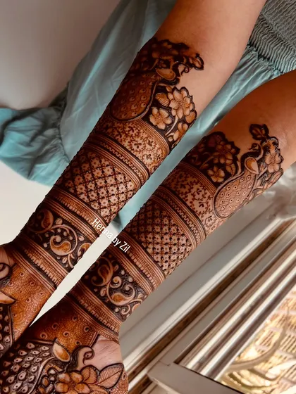 A view of the full arms, showing the symmetrical peacock and floral bands. The consistency in the pattern is key to a beautiful bridal look.