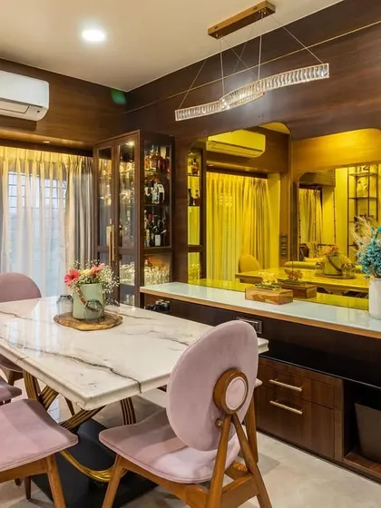 The dining area in this home features a marble-top table and plush pink chairs, creating a space that feels both elegant and inviting for family meals.
