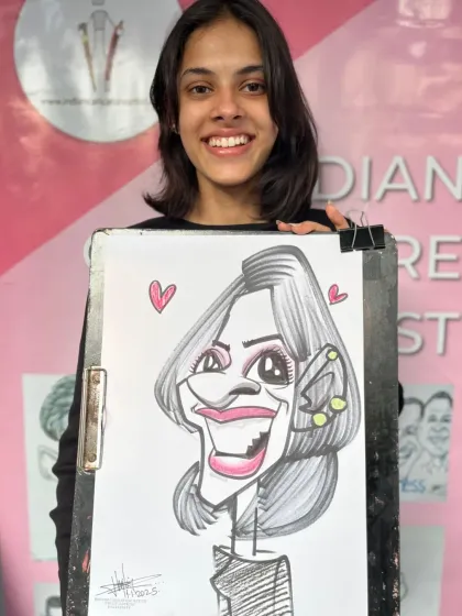 A smiling student with her caricature. The hearts add a sweet touch.