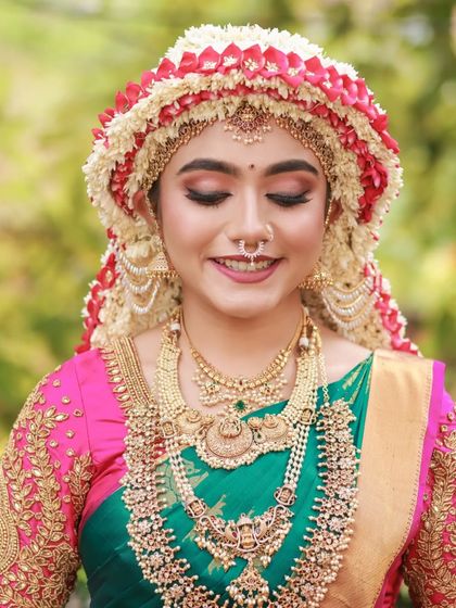 A series of images capturing the joy and beauty of a model in a traditional South Indian bridal look, complete with an elaborate floral headpiece. The focus is on her expressive smile and the rich textures of her attire.