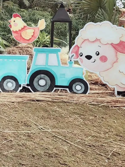 A cute cutout of a sheep next to a blue tractor. These props were scattered around the party area to make the entire space feel like a fun and friendly farm.