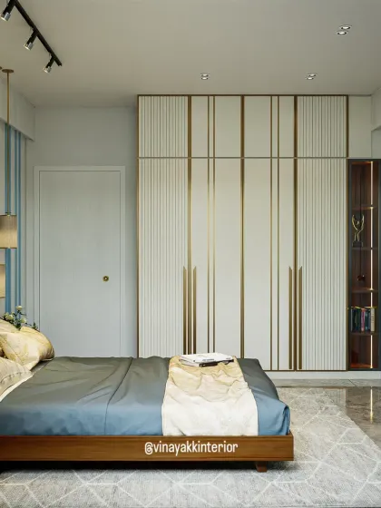 A different perspective of the blue and wood bedroom, focusing on the sleek, custom-designed wardrobe. The white panels with vertical gold inlay provide a touch of elegance and make the room feel spacious and bright.