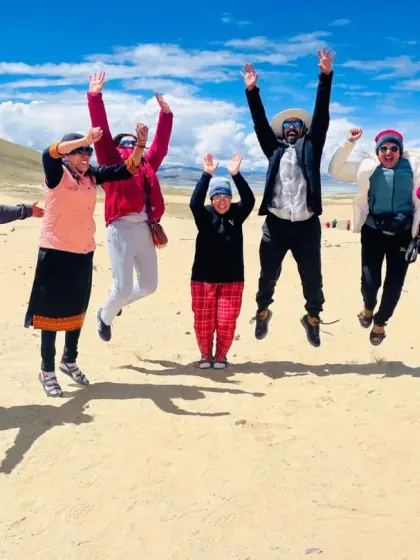 A moment of pure joy and exuberance in the sand dunes of Tibet. The spiritual journey is not always solemn; it is also filled with laughter and a celebration of life.