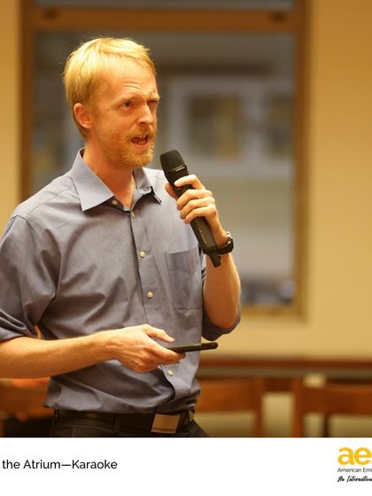 A faculty member takes the stage during karaoke, showcasing the hidden talents within our staff. These informal arts events help break down barriers and connect students and teachers in a fun, new way.