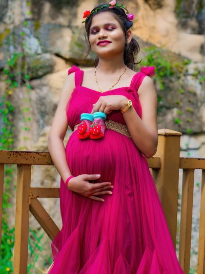 A serene solo portrait holding a pair of tiny red baby shoes over the bump. This is a sweet and symbolic way to include the baby in the photos.
