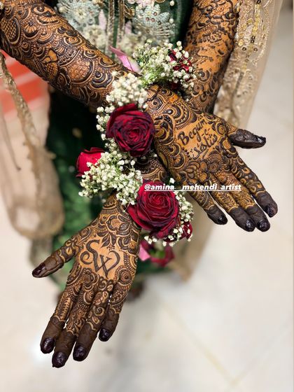 I love when brides accessorize with floral jewelry. The red roses and baby's breath look stunning against the dark henna.