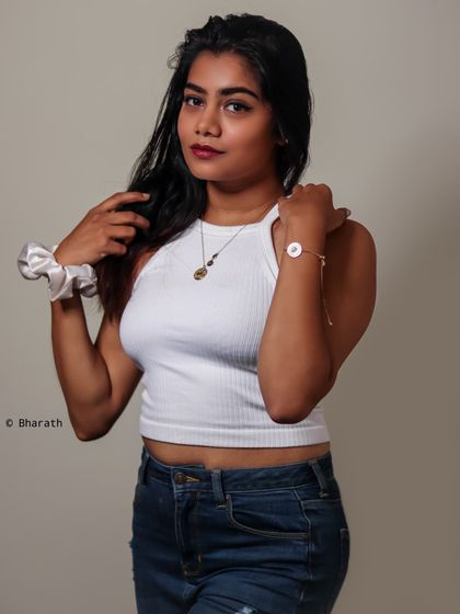 This studio portrait uses a simple setup, a white top and jeans, to create a photo that feels authentic and approachable.