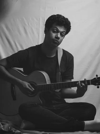 A self-portrait with my guitar. I also enjoy photography, and sometimes I turn the camera on myself to capture a mood. This was a high-key lighting setup.