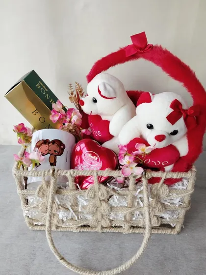 Spreading love on Valentine's Day with a sweet and cuddly hamper. This basket is filled with cute teddy bears, a "You're my other half" mug, and delicious chocolates.