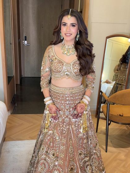 A bride looking effortlessly elegant with her hair styled in simple, soft waves for one of her wedding functions. This look is all about natural beauty.