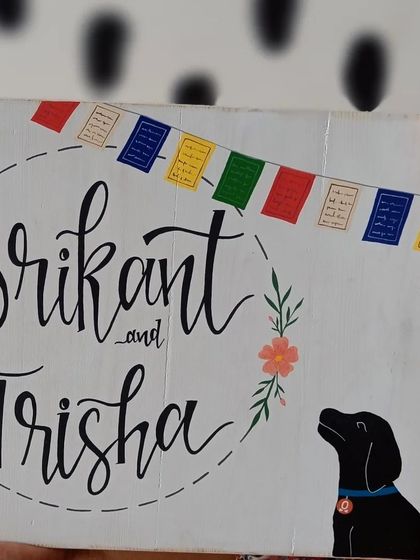 A close-up of the details on a custom name board. We included the family's beloved dog and Tibetan prayer flags to represent their personalities and love for travel.