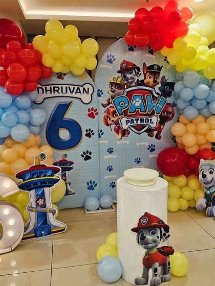 This is a duplicate of ID 19. A fun and colorful Paw Patrol theme for a 6th birthday. The decoration features a large backdrop with the whole pup squad, character cutouts, and a marquee number '6'.