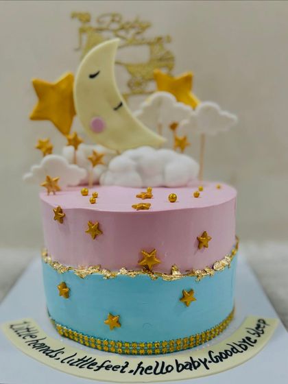 A dreamy "Twinkle Twinkle Little Star" themed baby shower cake. This pink and blue cake features a sleeping moon, fondant stars, and a sweet message for the baby.