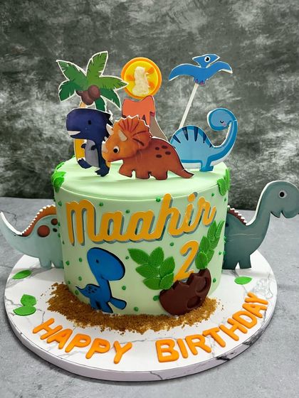 A dino-mite birthday cake for a young dinosaur enthusiast. This cake is covered in friendly dinosaur cutouts, fondant leaves, and edible dirt, creating a fun prehistoric scene.