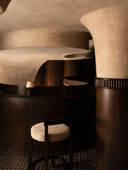 The private dining area, where the ceiling forms a sculptural canopy. I designed this intimate space to feel like a secluded chamber, using dark wood and focused lighting to create a sense of exclusivity.