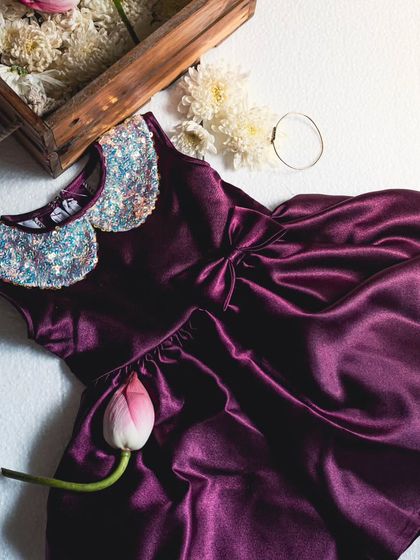 This wine-colored satin dress is perfect for a sophisticated look. The sequined collar and full skirt make it an elegant choice for holiday parties or formal family events.