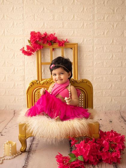 A sweet and happy portrait of the birthday girl, looking confident and cute in her vibrant pink ensemble.