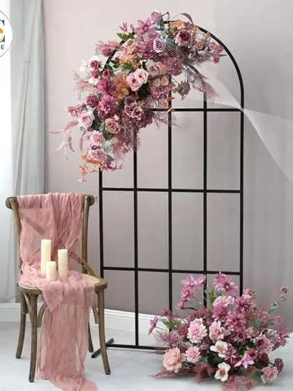 A minimalist and modern decor piece, featuring a simple black arch with an asymmetrical floral arrangement, perfect for a chic, understated event.