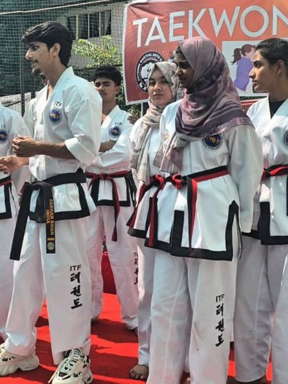My black belt and red belt students standing on stage during a demonstration.