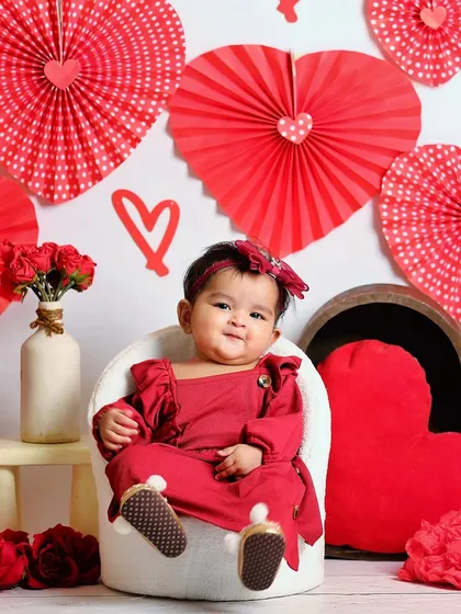 A Valentine's Day themed sitter session. Dressed in red and surrounded by hearts, this little one is the perfect picture of love.