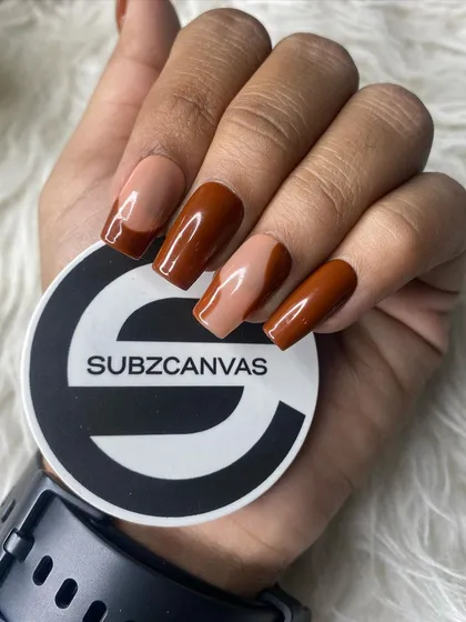 A close-up of the modern French tip design from the press-on kit. The rich brown color offers a contemporary twist on a classic style, shown here in a square shape.