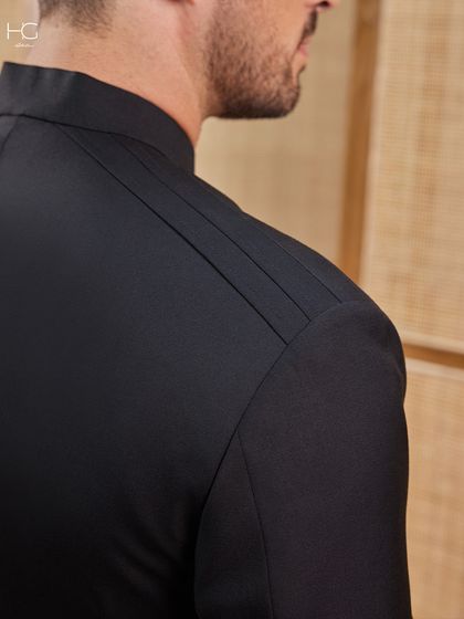 A close-up on the shoulder of the bandhgala, highlighting the clean lines and pleated detail that give the garment its architectural and modern feel.