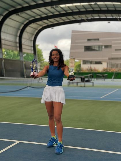 A double crown achievement. Yashi proudly displays her singles and doubles trophies from the AITA 1 Lakh tournament in Hyderabad, showcasing her versatility and skill.