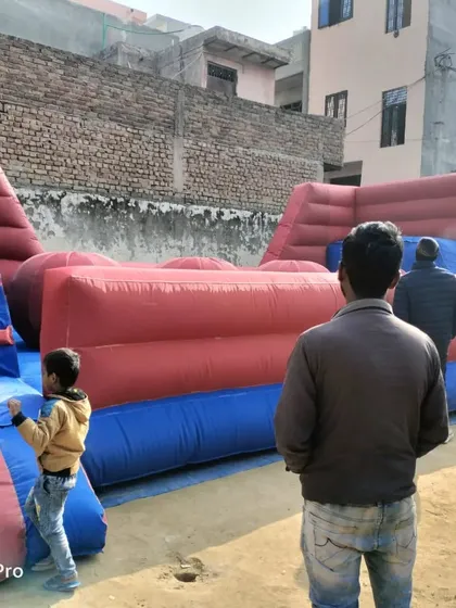 Kids and adults enjoying the inflatable 'Baller Game'. This action shot shows how engaging this type of obstacle course is for all ages.