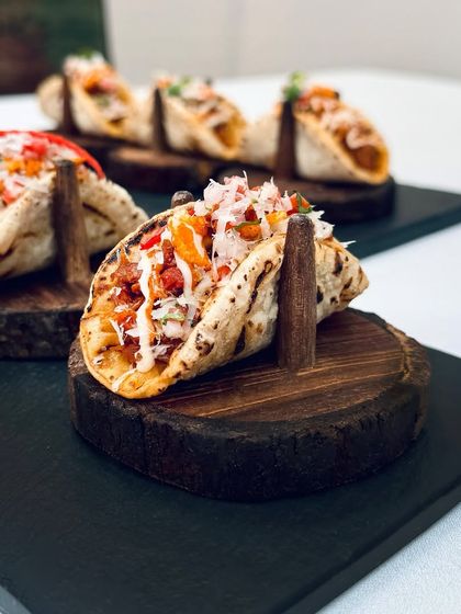 Our pulled jackfruit phulka tacos are presented on custom wooden holders, a dish that perfectly marries global concepts with Indian flavours and craftsmanship.