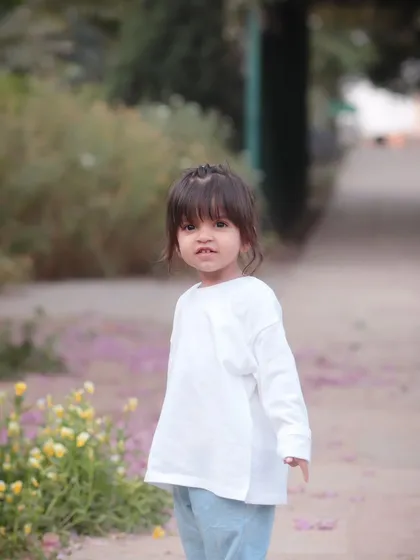 A little girl exploring a garden path. Our outdoor sessions are perfect for adventurous toddlers who love to be on the move.