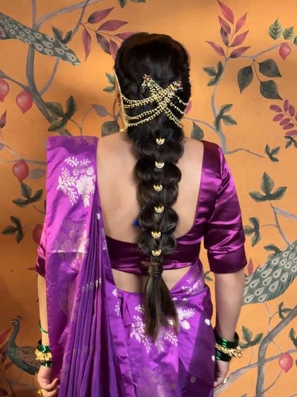 For Ganesh Chaturthi, we created this divine Gauree Devi look. The messy braid is adorned with a traditional Chandrakor, perfectly complementing the purple nauvari saree and temple jewelry.