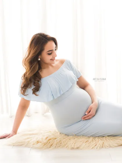 A serene seated portrait on a soft fur rug. This pose is comfortable and creates a beautiful, gentle composition against the bright background.