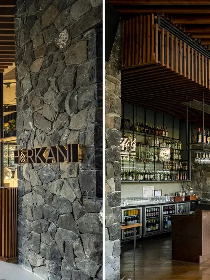 The entrance to the restaurant and the bar area at the Radisson Resort are defined by heavy stone pillars and rich wooden details, grounding the modern design in the region's material history.