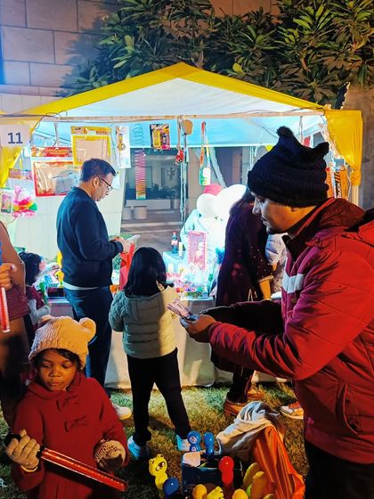 A festive winter exhibition with families and children enjoying the atmosphere and shopping for unique gifts.