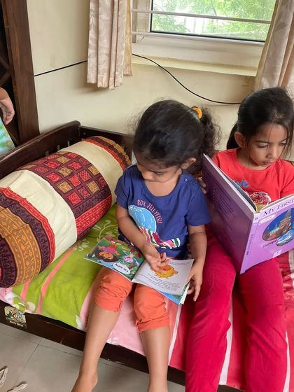 A similar shot showing the girls engrossed in their individual books, a perfect example of parallel reading.