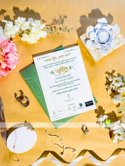 A clean and elegant flat-lay of a building-themed inauguration card. The design uses a simple color palette and high quality paper stock to create a professional and stylish announcement for a grand opening ceremony.