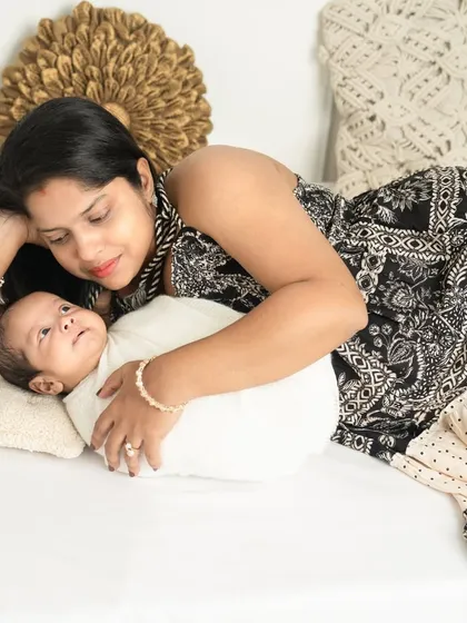 A mother gazing at her newborn with pure adoration. This relaxed pose captures a quiet, everyday moment of love.
