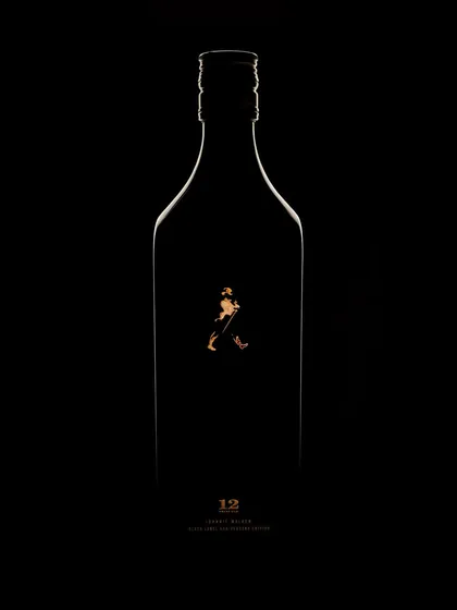 A wider view of the minimalist Johnnie Walker concept. Here, you see the full silhouette of the bottle, defined by a thin, golden line of light. It's a testament to how much can be said with very little, focusing on shape and brand identity.