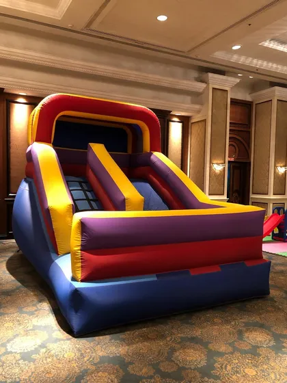 This compact inflatable slide is specifically designed for indoor use in venues like banquet halls with limited space. It provides a fun sliding experience for younger children in a safe, contained unit.