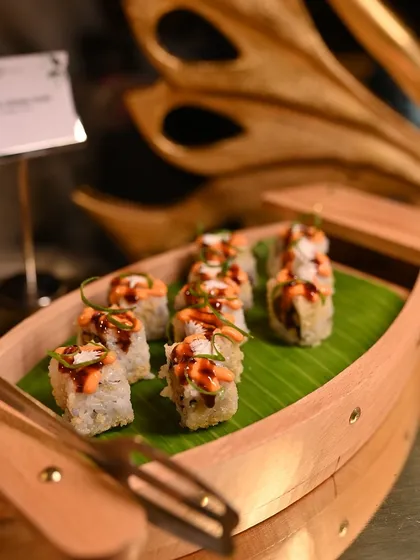 Another variety of sushi rolls, elegantly presented in a wooden boat, highlighting the diversity of options available at our live station.
