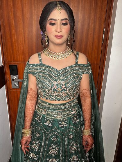 A gorgeous party look in a deep green lehenga. The makeup features a soft brown smokey eye and a flawless base, perfect for an engagement or sangeet.