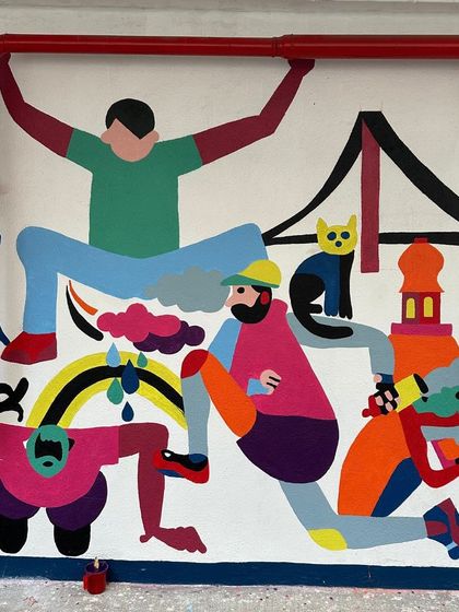 A section of the festival mural featuring playful, colorful figures and local landmarks.