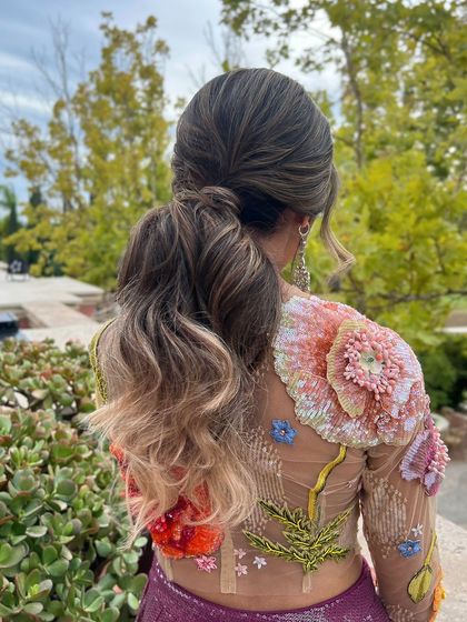 A textured, wavy low ponytail, a comfortable and chic choice for a Mehandi day.