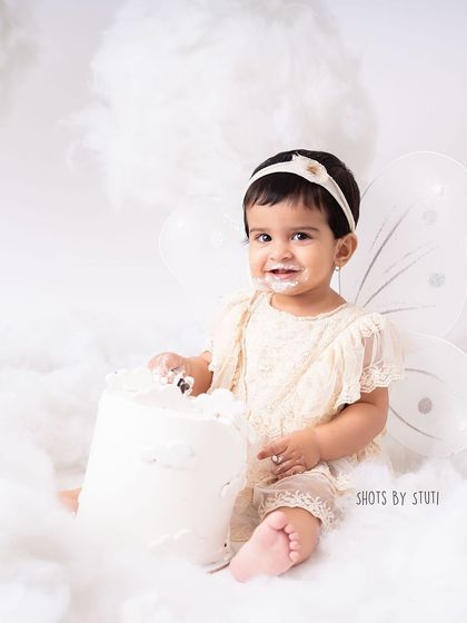 Another shot from the dreamy cloud setup. The soft, fluffy "clouds" create a beautiful texture and a magical atmosphere for her first birthday photos.
