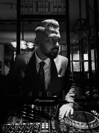 A sharp, black and white portrait of me at the decks. This look is perfect for weddings, sangeets, and high-end corporate functions.