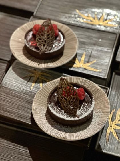 A pair of our exquisite chocolate tarts, presented on textured plates that complement their artisanal quality.